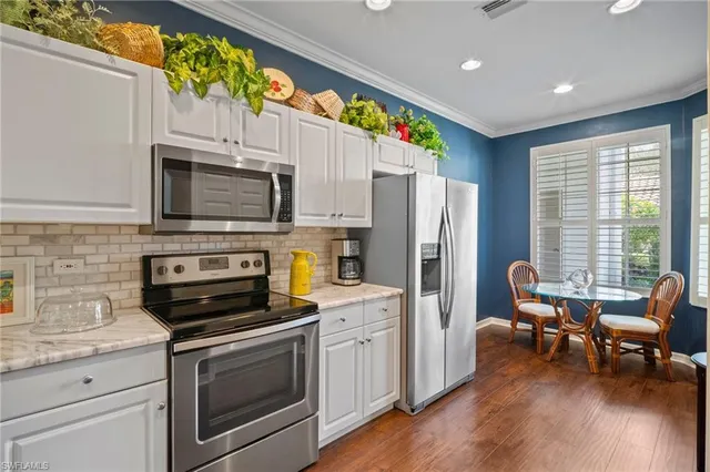 a kitchen with a sink stainless steel appliances and furniture