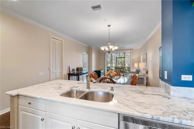 a view of a kitchen with a sink and chandelier