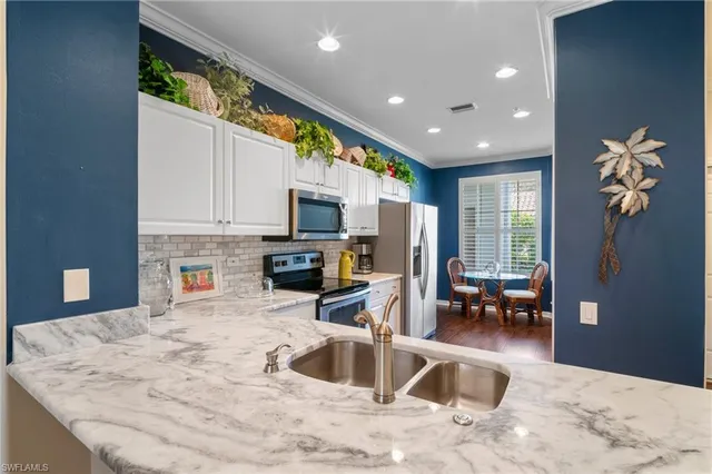 a kitchen with stainless steel appliances granite countertop a sink a stove and a refrigerator