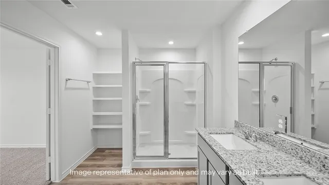 a bathroom with a granite countertop sink a mirror and a shower