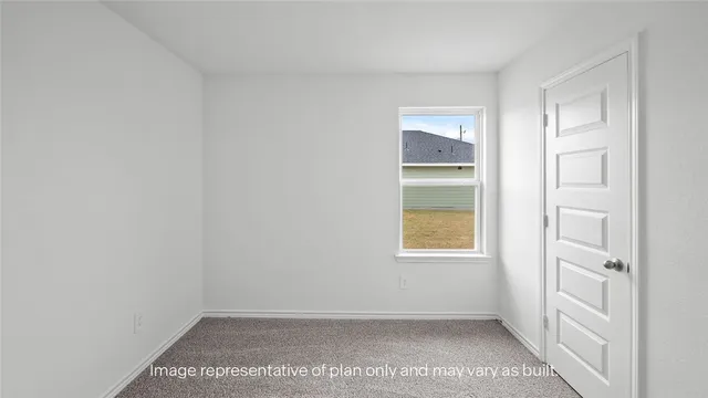 a view of an empty room with a window and a bathroom