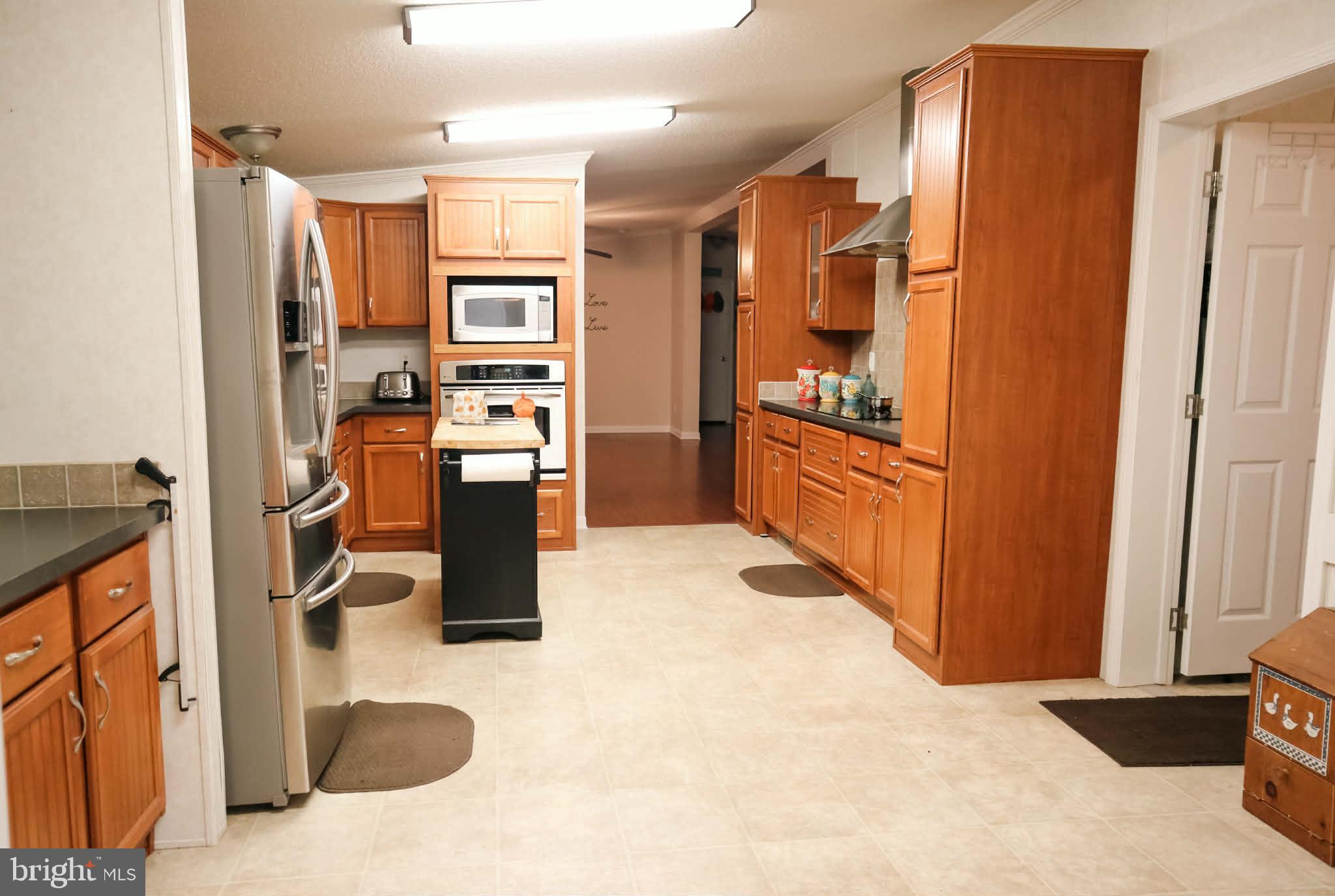 39 Queen Eleanor Drive Elkton, MD 21921 - Photo 3 of 11 a kitchen with stainless steel appliances kitchen island granite countertop a refrigerator and a stove top oven