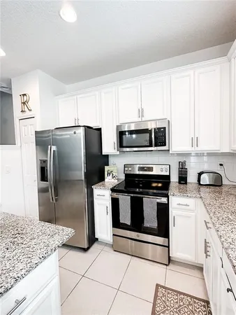 a kitchen with granite countertop a refrigerator and a sink