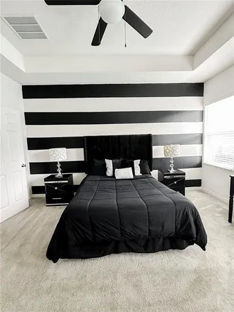 a bedroom with a bed a window and a chandelier