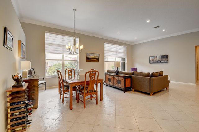 a large kitchen with granite countertop a large kitchen island white cabinetry and stainless steel appliances