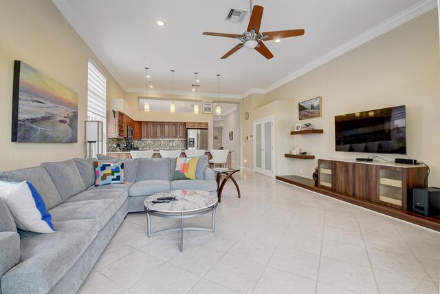 a kitchen with stainless steel appliances kitchen island granite countertop a refrigerator a stove a kitchen island with chairs and white cabinets