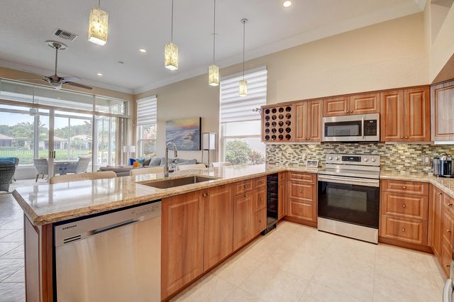 a kitchen with stainless steel appliances granite countertop a stove a sink and a microwave
