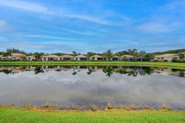 a aerial view of a house with a big yard and potted plants and large trees