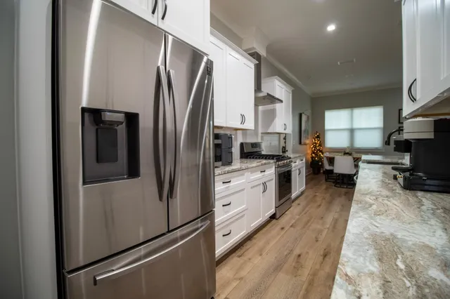 a kitchen with stainless steel appliances a refrigerator sink and microwave