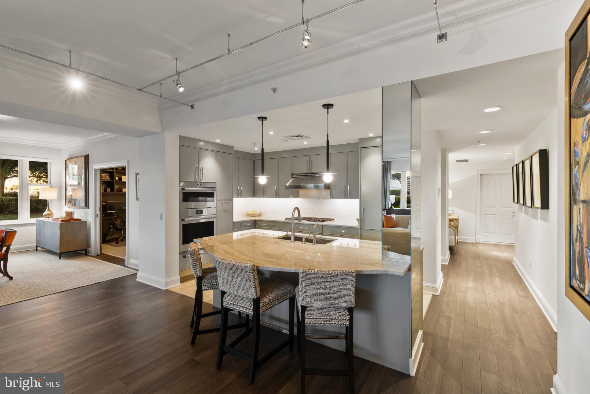 801 Key Highway, Unit 110 Baltimore, MD 21230 - Photo 16 of 78 a dining room with stainless steel appliances kitchen island granite countertop a table chairs and a refrigerator