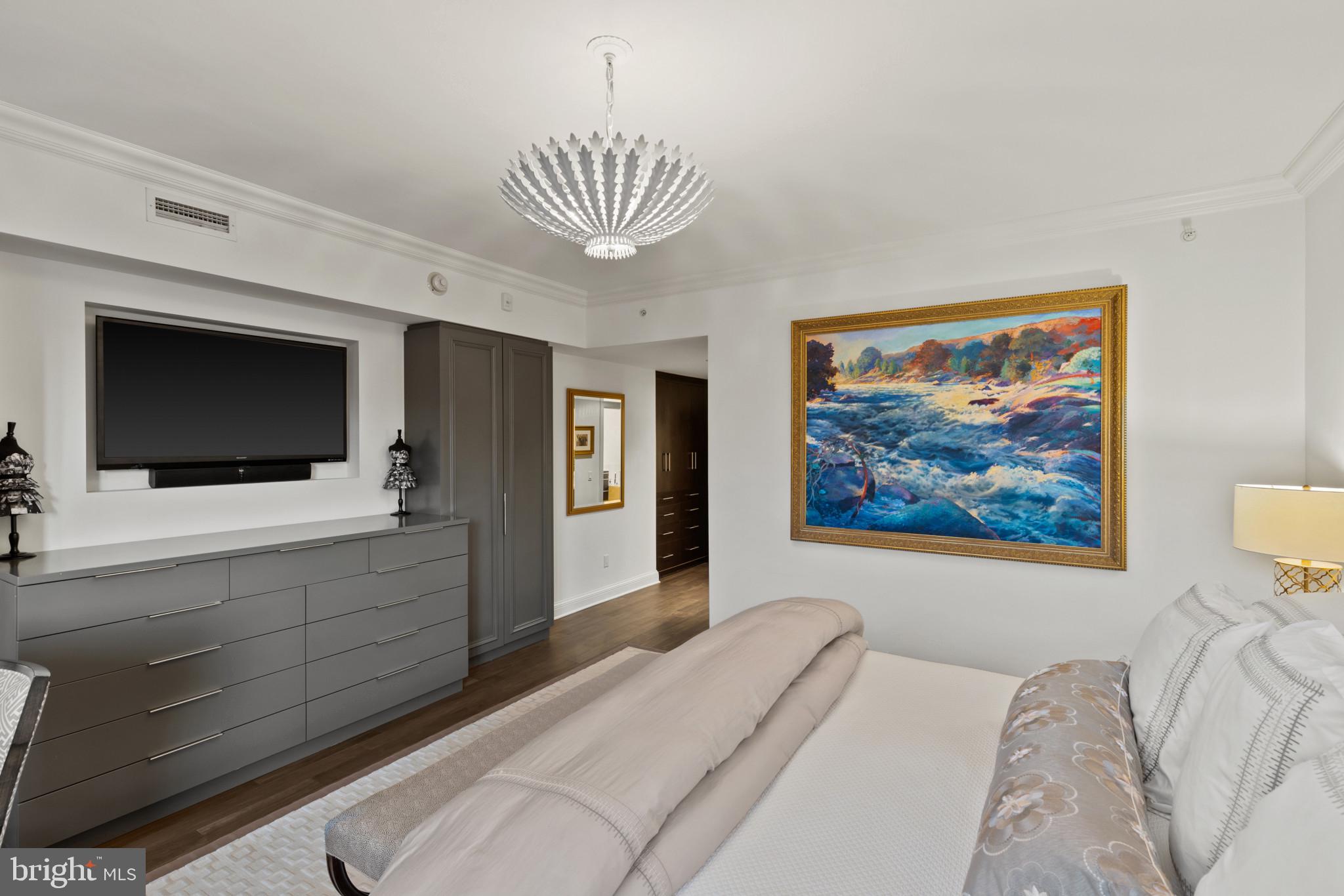 801 Key Highway, Unit 110 Baltimore, MD 21230 - Photo 35 of 78 a bedroom with a large bed a flat tv screen and a chandelier