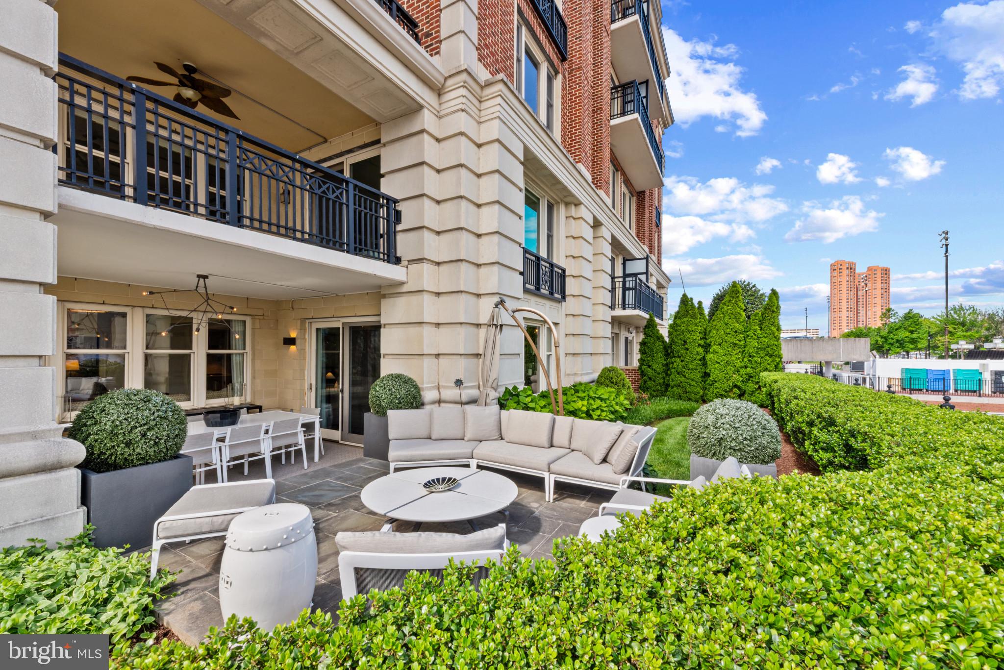 801 Key Highway, Unit 110 Baltimore, MD 21230 - Photo 53 of 78 a view of a patio with couches table and chairs potted plants and large tree