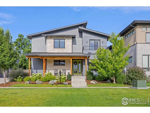 a front view of a house with a yard and trees