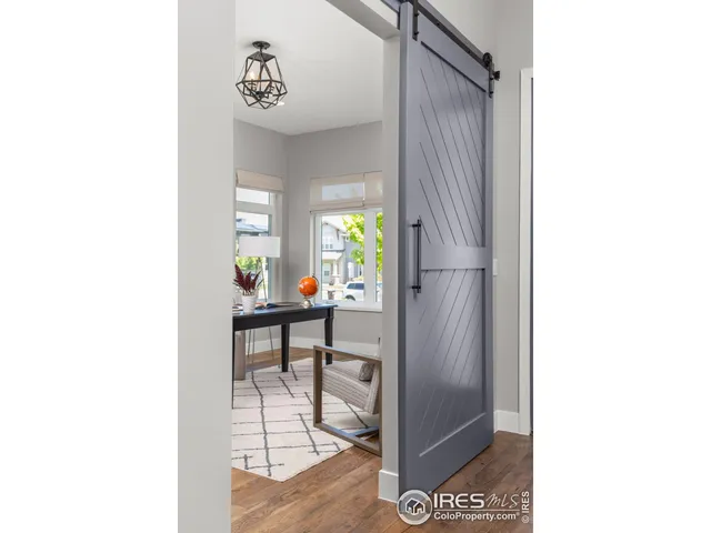 a view of a hallway with wooden floor and a living room