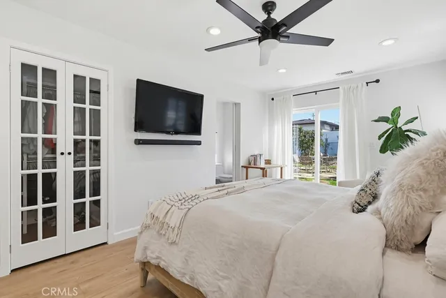 a bedroom with a bed tv and a window