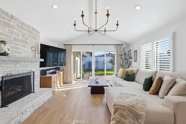 a living room with furniture fireplace and large windows