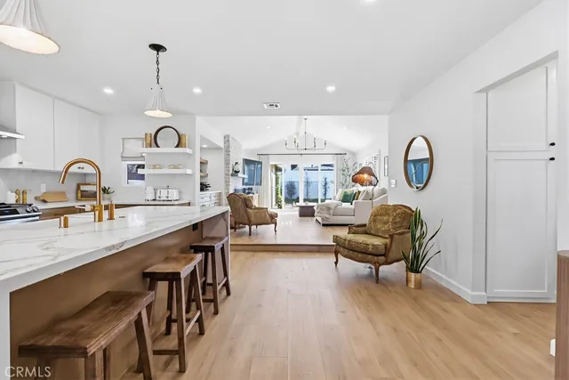 a living room with furniture a table and kitchen view