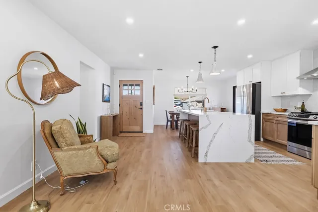 a living room with furniture a kitchen view and a chairs