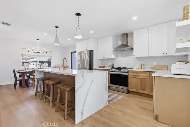 a kitchen with kitchen island granite countertop a sink a counter top space and stainless steel appliances