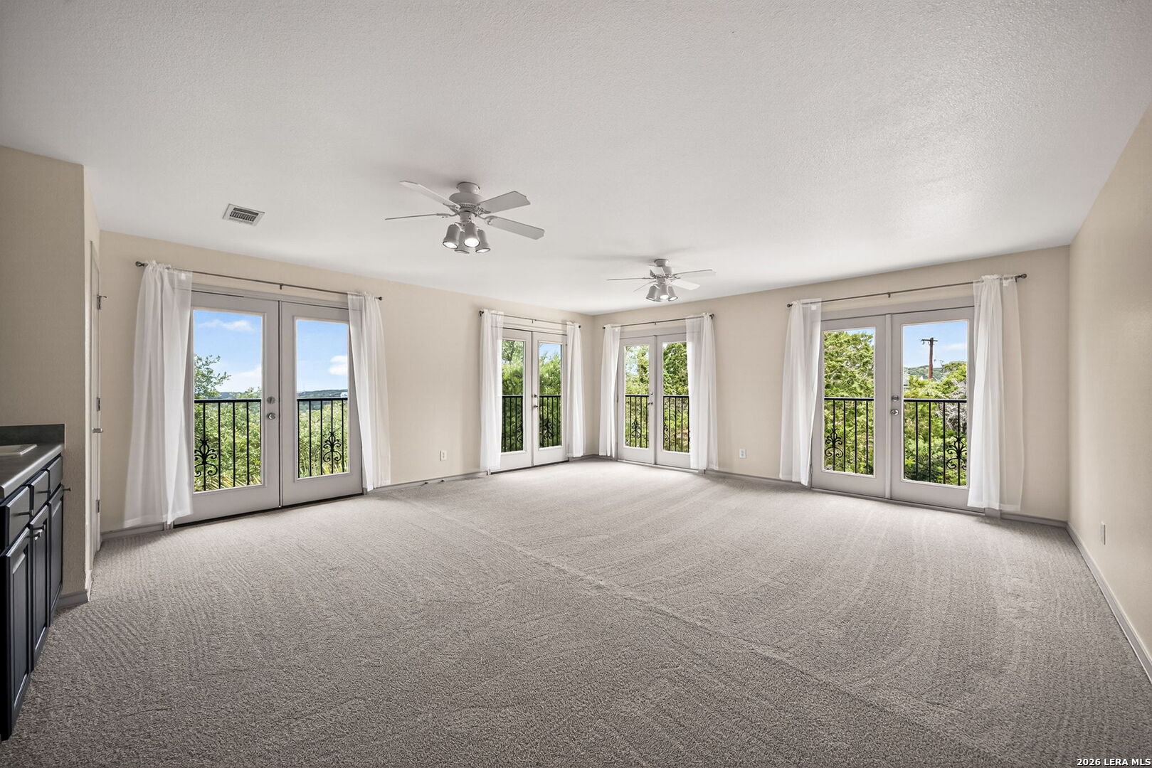 17431 Helotes Spring Road Helotes, TX 78023 - Photo 35 of 50 a view of a big room with windows and chandelier fan