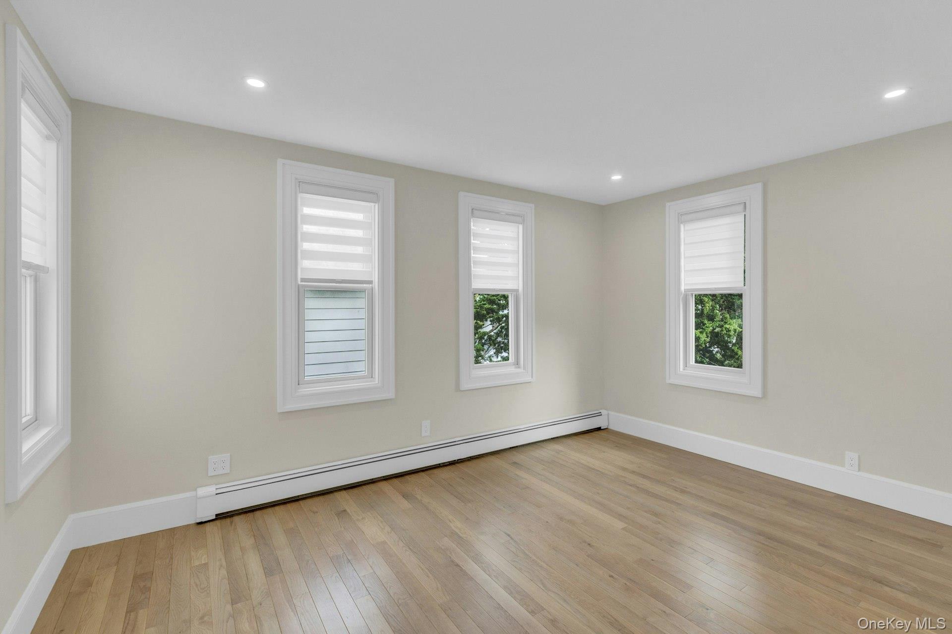 76 Green Street, Unit #2 Huntington, NY 11743 - Photo 18 of 28 an empty room with wooden floor and windows