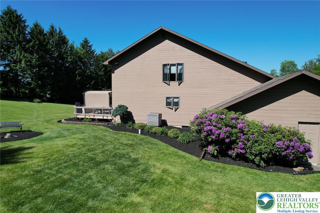 3470 Brodhead Road Bethlehem, PA 18020 - Photo 24 of 84 A verdant lawn frames this inviting home, featuring a spacious deck and blooming shrubbery.