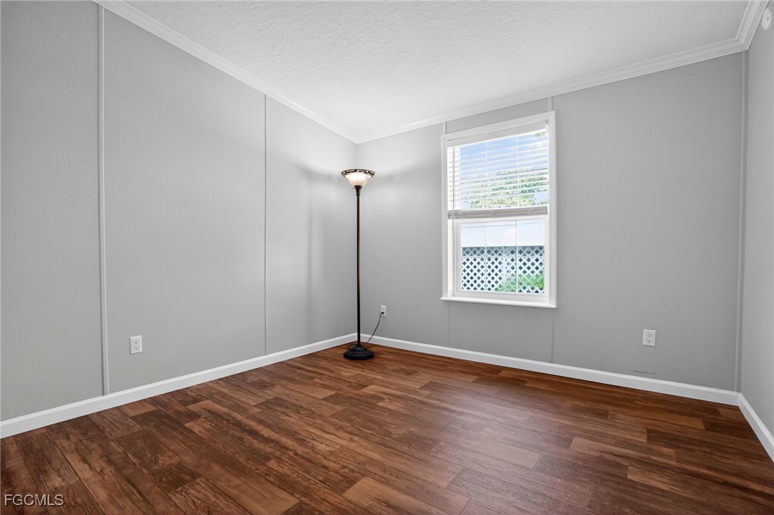 516 Menton Lane Naples, FL 34112 - Photo 16 of 34 a view of an empty room with wooden floor and a window