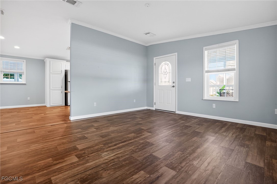 516 Menton Lane Naples, FL 34112 - Photo 3 of 34 an empty room with wooden floor and windows