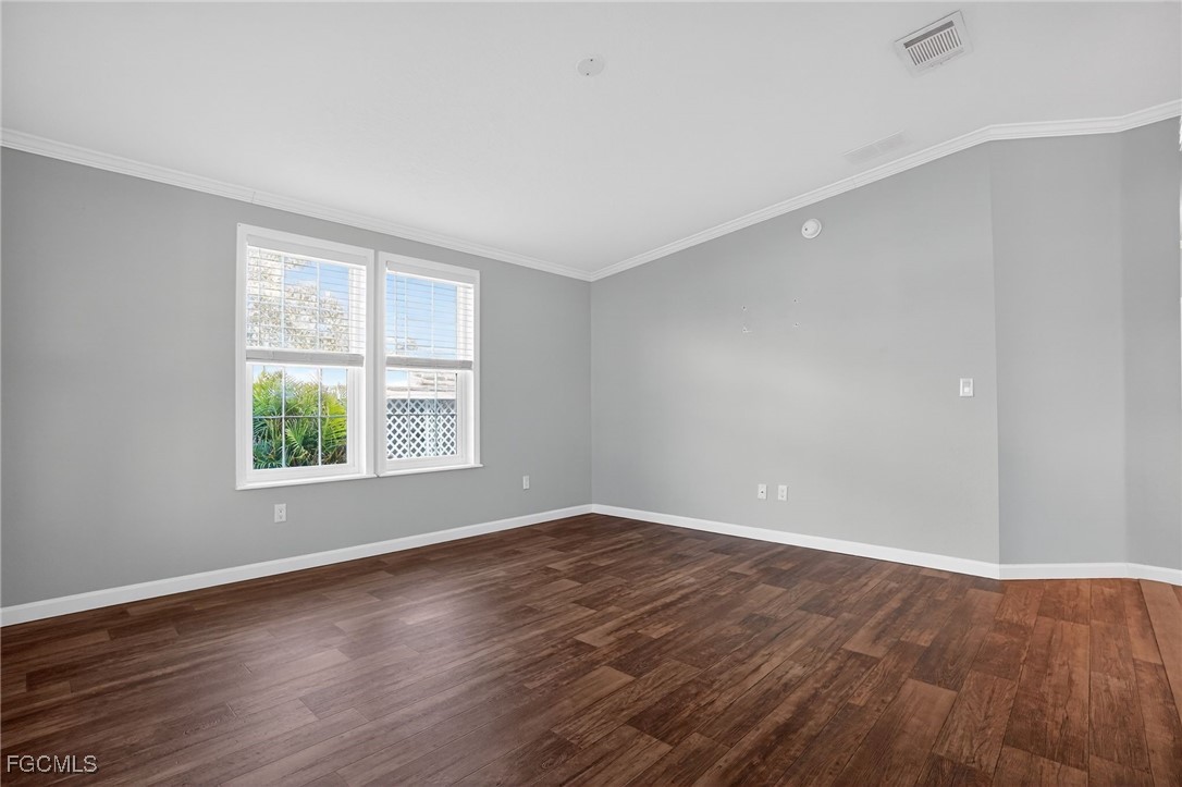 516 Menton Lane Naples, FL 34112 - Photo 4 of 34 an empty room with wooden floor and windows