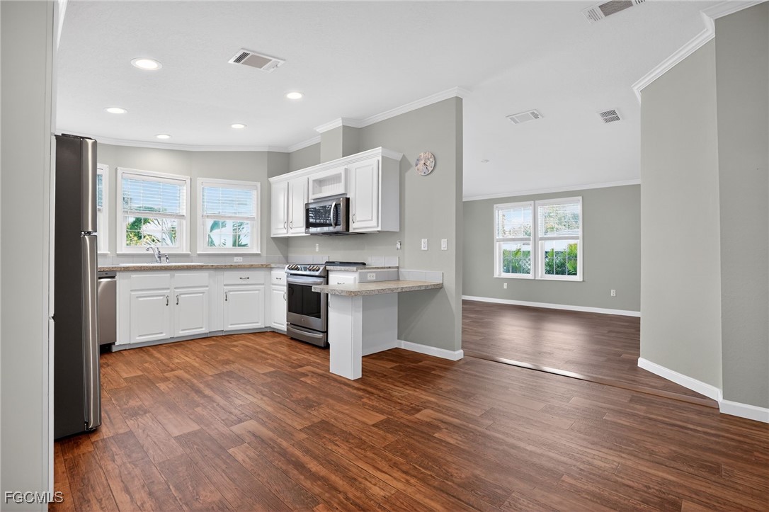 516 Menton Lane Naples, FL 34112 - Photo 10 of 34 a kitchen with stainless steel appliances a white stove top oven and a sink