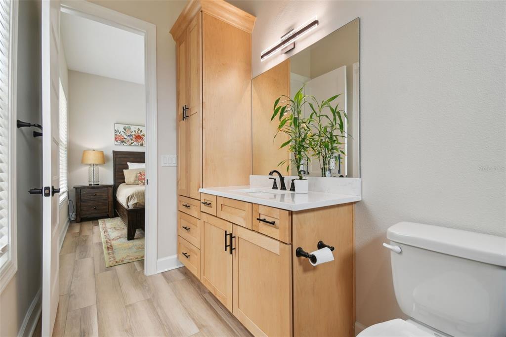 13711 Lussier Lane Spring Hill, FL 34610 - Photo 15 of 100 a en suite bathroom with a sink a mirror a toilet and a shower