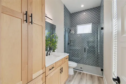 a bathroom with a sink a toilet and shower