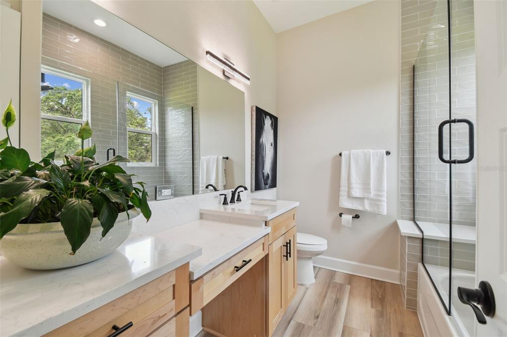 13711 Lussier Lane Spring Hill, FL 34610 - Photo 75 of 100 a bathroom with a granite countertop sink a mirror a potted plant and a bathtub