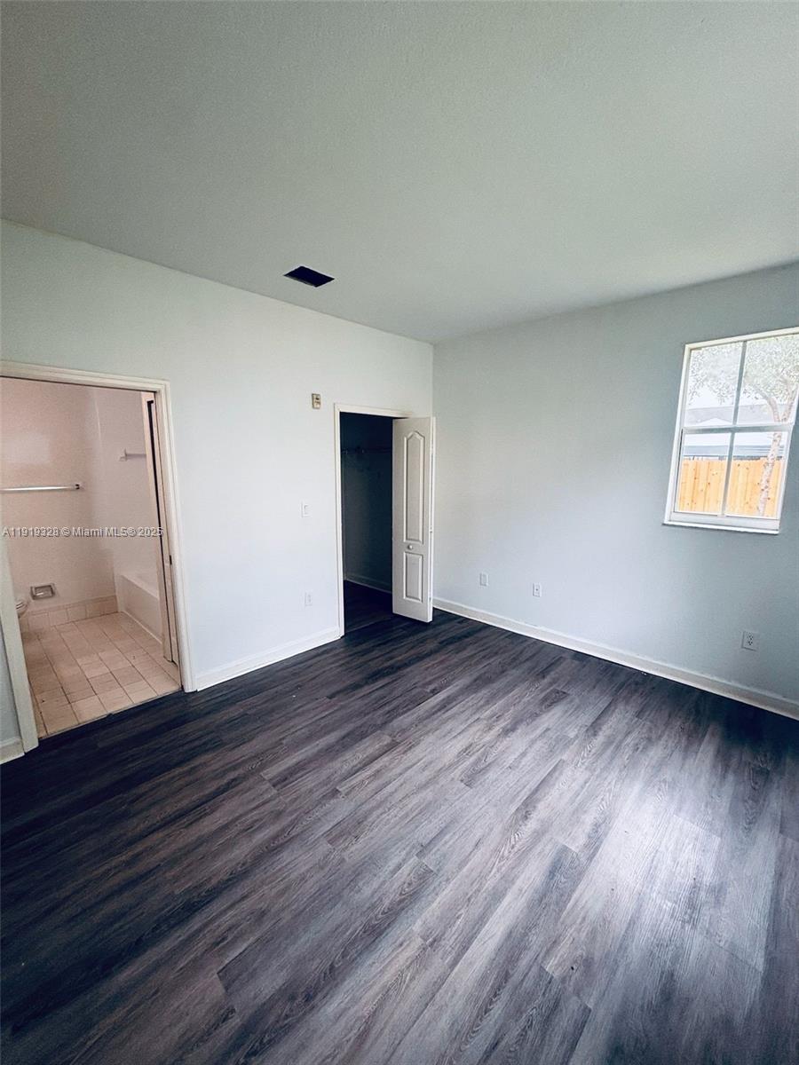 1663 Southeast 29th Street, Unit 100 Homestead, FL 33035 - Photo 12 of 15 an empty room with wooden floor and windows