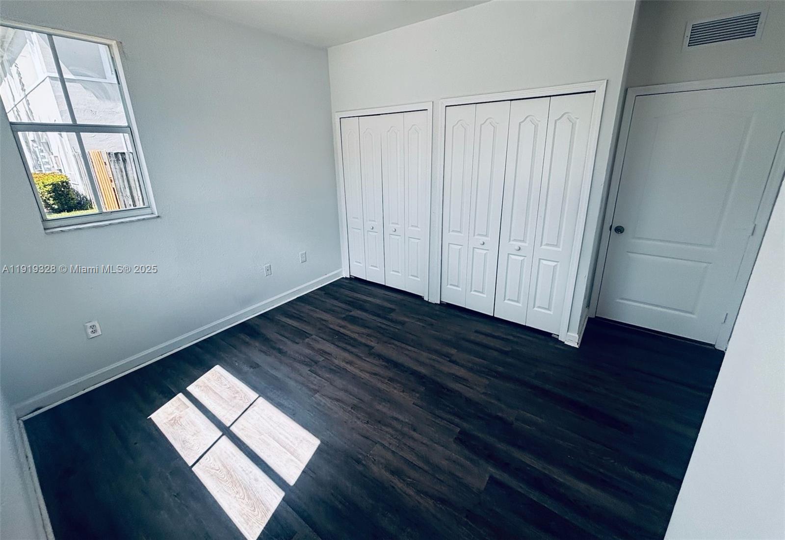 1663 Southeast 29th Street, Unit 100 Homestead, FL 33035 - Photo 6 of 15 a view of empty room with wooden floor and fan