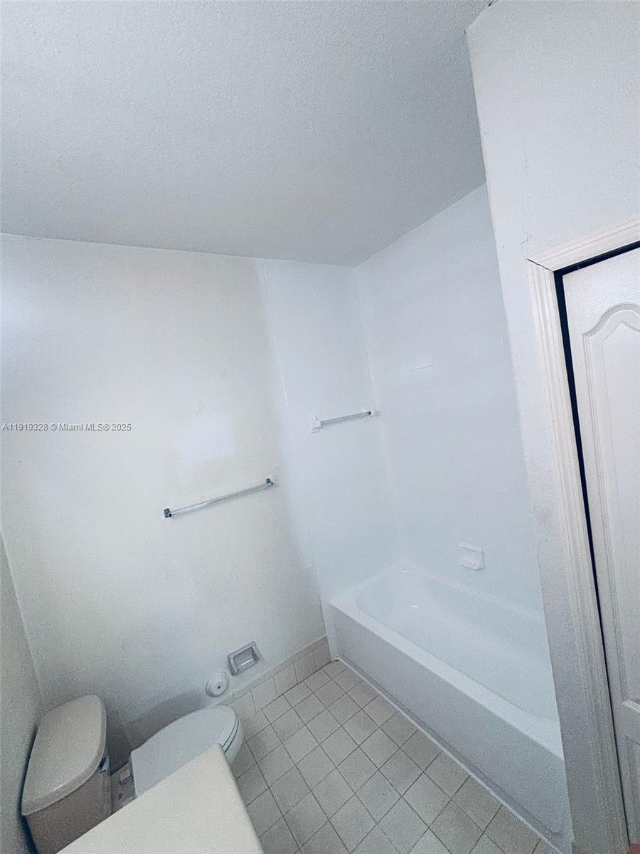 1663 Southeast 29th Street, Unit 100 Homestead, FL 33035 - Photo 8 of 15 a bathroom with a toilet and a bathtub