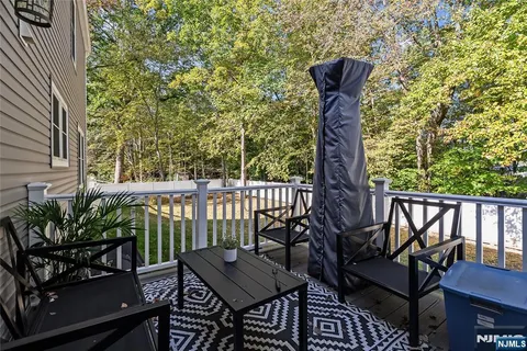 a balcony with wooden floor outdoor seating and trees