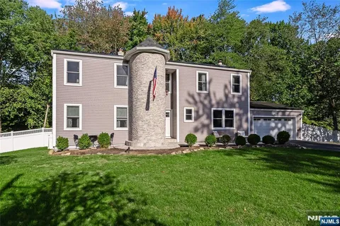a front view of a house with a garden and yard