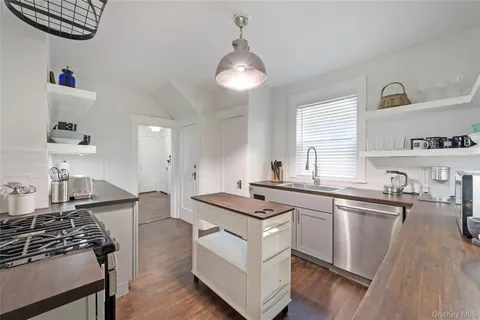 a kitchen with granite countertop a sink stove and cabinets