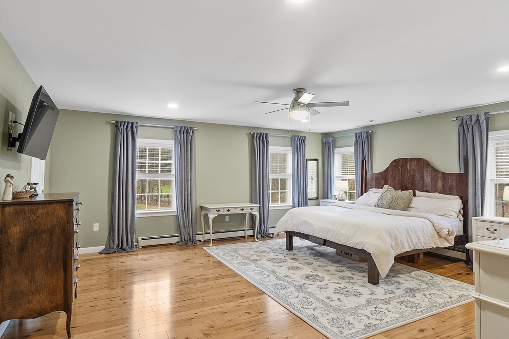 90 South Road Pepperell, MA 01463 - Photo 16 of 41 a bedroom with a large bed a flat tv screen and a dresser