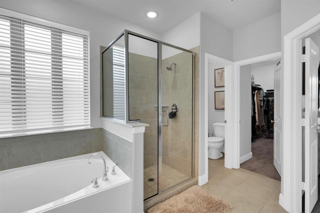 1498 Weston Road Dallas, TX 75234 - Photo 16 of 24 Contemporary bathroom featuring a built-in soaking tub, a glass-enclosed shower with tiled walls, chrome fixtures, and a window with horizontal blinds