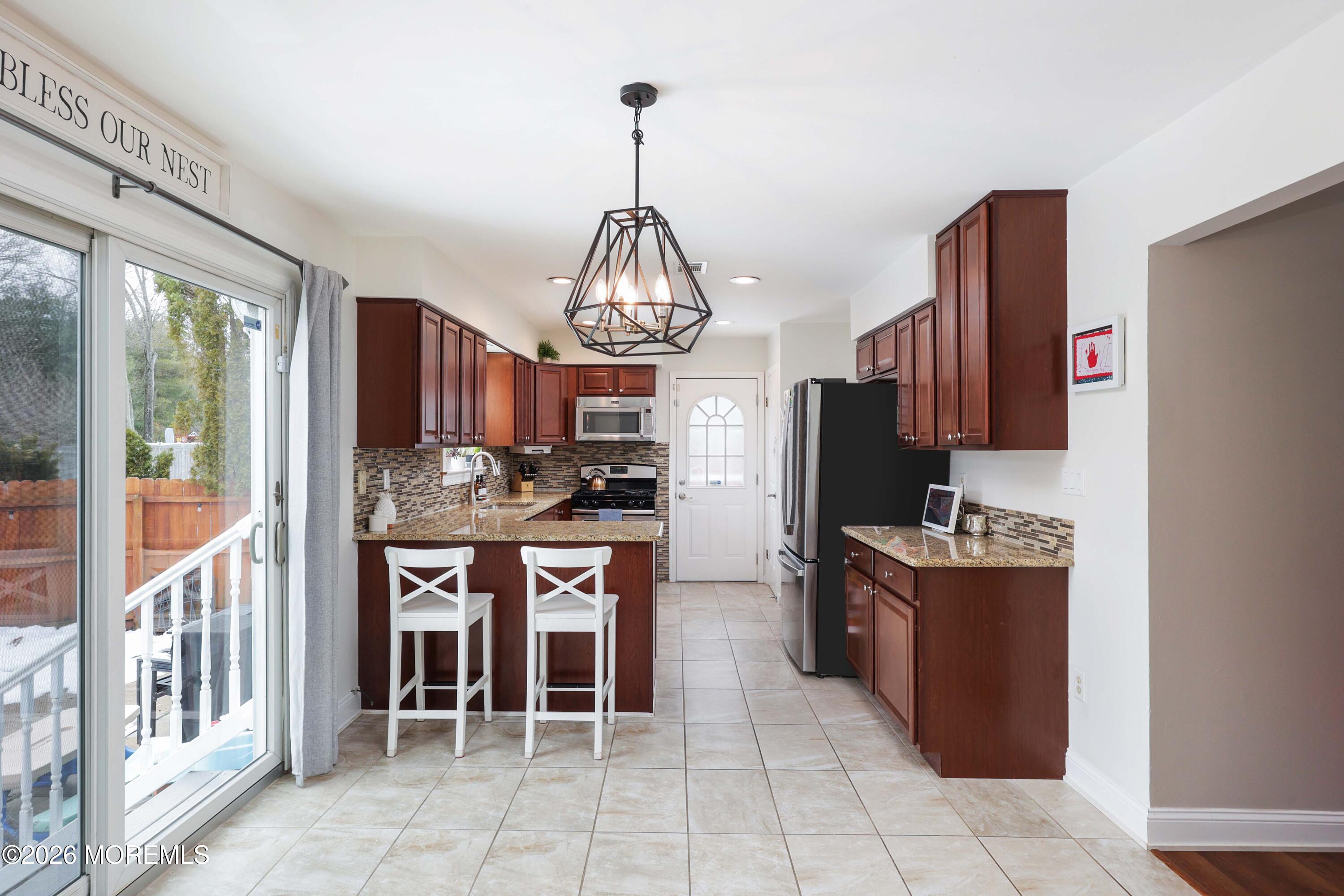 27 Jennifer Drive Howell, NJ 07731 - Photo 5 of 27 a kitchen with granite countertop a table and chairs