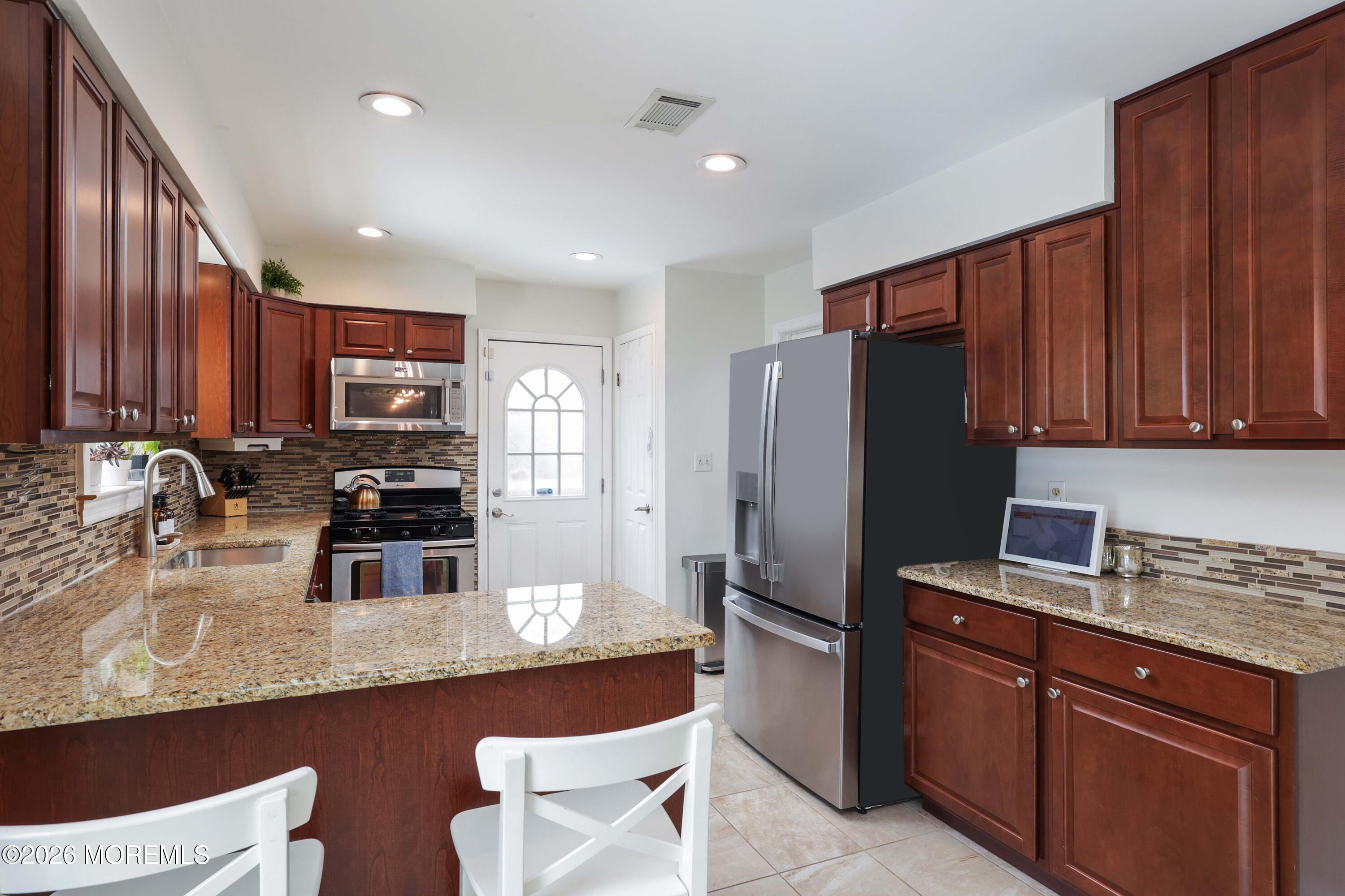 27 Jennifer Drive Howell, NJ 07731 - Photo 8 of 27 a kitchen with stainless steel appliances granite countertop a refrigerator stove a sink and dishwasher