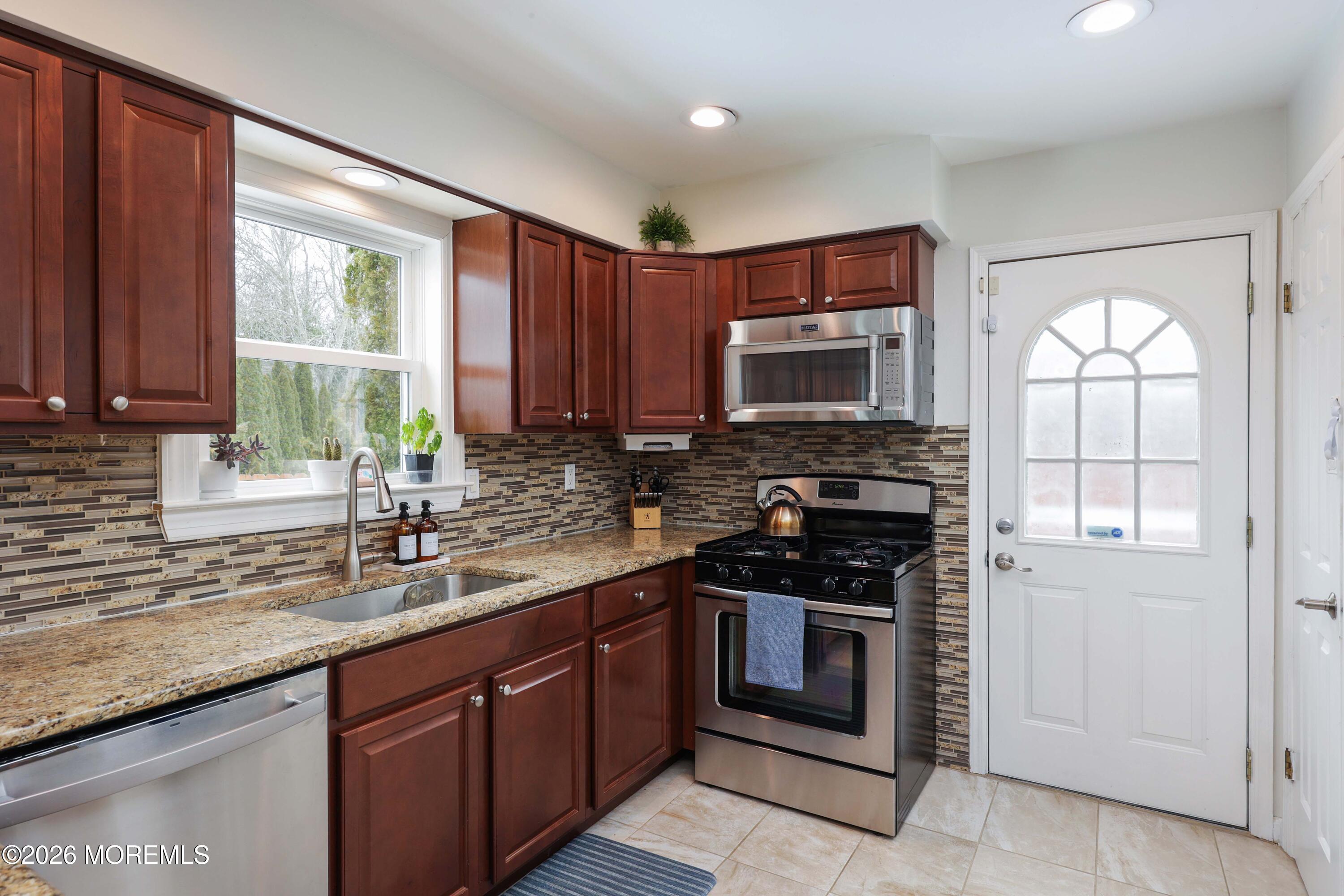 27 Jennifer Drive Howell, NJ 07731 - Photo 9 of 27 a kitchen with sink a microwave and cabinets