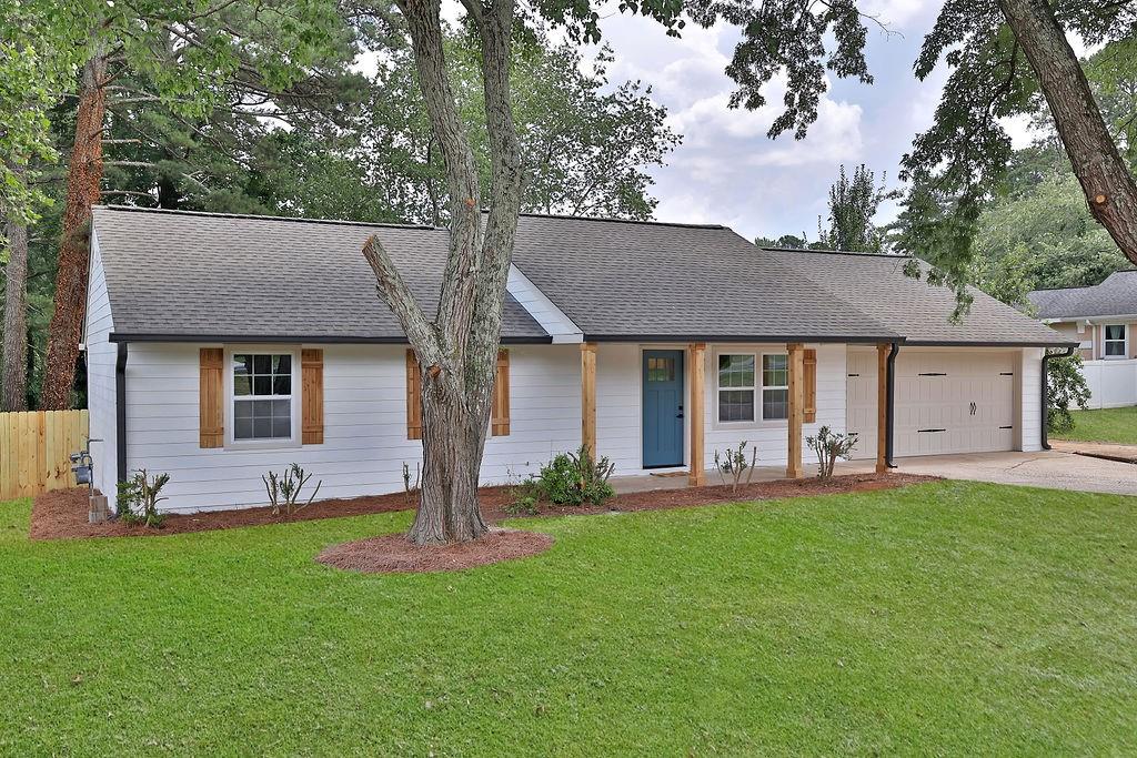 1208 Monfort Road Lawrenceville, GA 30046 - Photo 1 of 1 a front view of a house with a garden and trees