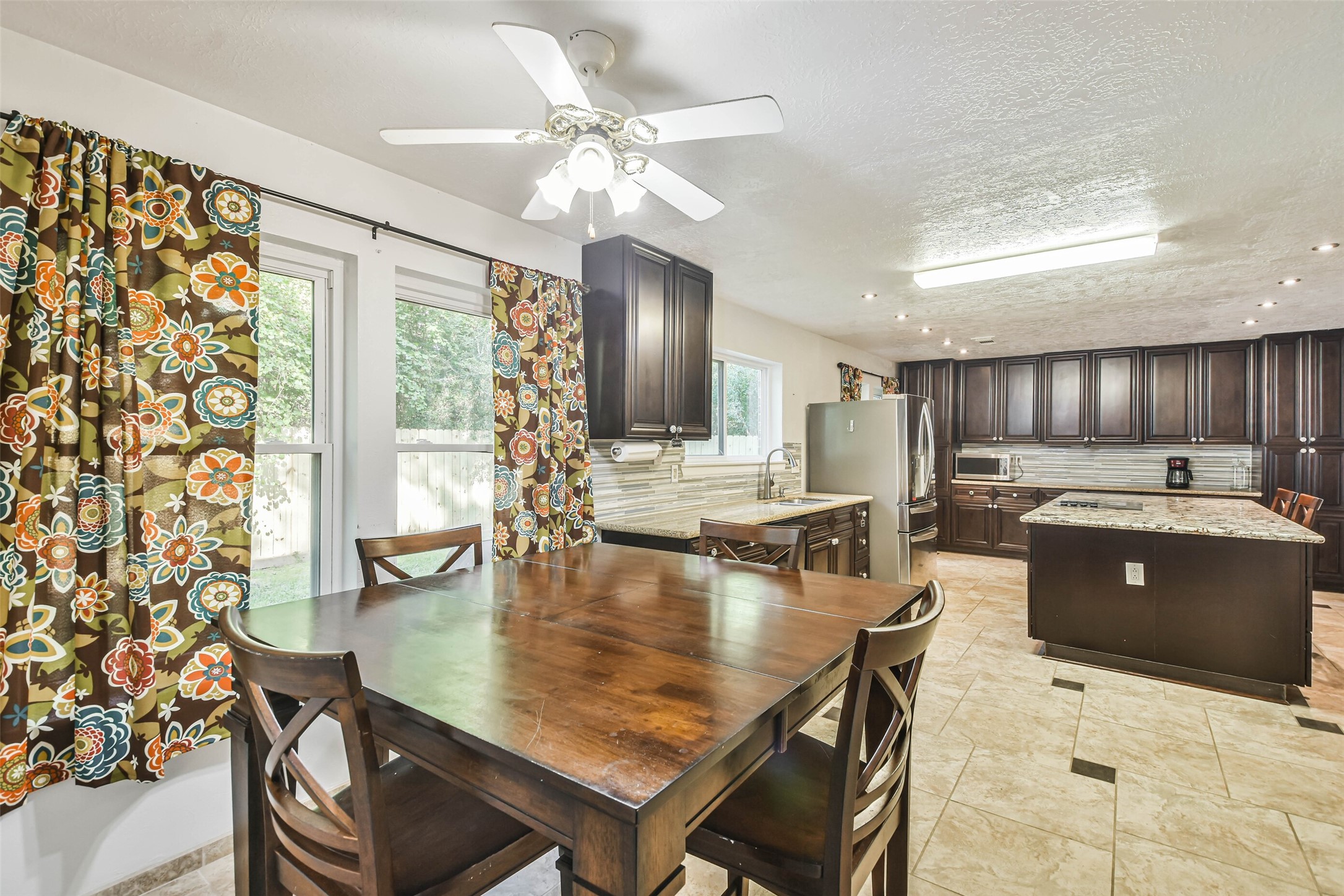 12 Coralberry Road Spring, TX 77381 - Photo 13 of 45 a large kitchen with kitchen island a stove a table and chairs in it