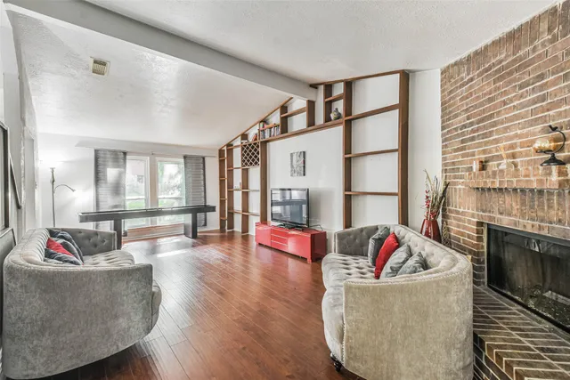 a living room with furniture fireplace and dining table with wooden floor
