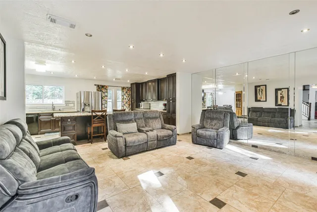 a living room with furniture and view of kitchen