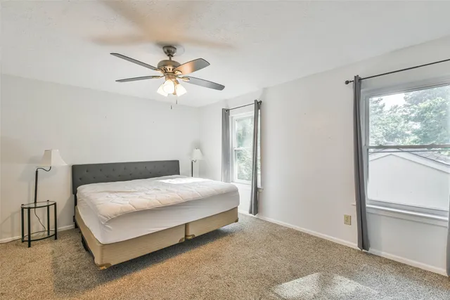 a bedroom with a bed and a ceiling fan