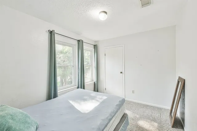 a bedroom with a bed and a large window